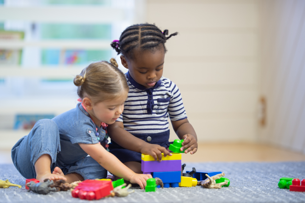 Two young children in the Montessori sensitive period for social awareness playing with each other