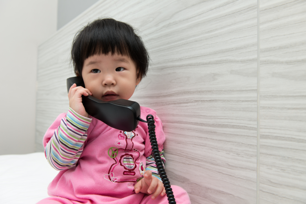 Baby in sensitive period for language talking into a phone